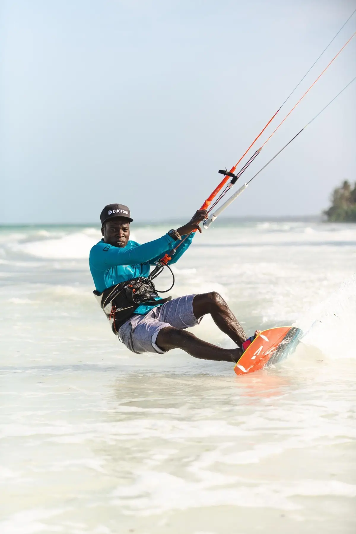 Kitesurfař projíždí po mělčině u zanzibarské pláže