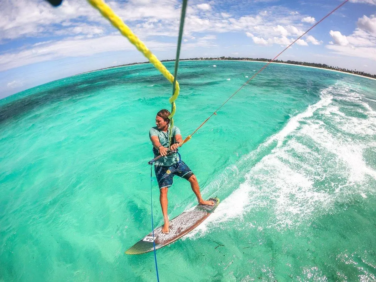 Kitesurfař jede po tyrkysovém oceánu u Zanzibaru